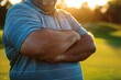 © Olsek - Portrait of a man with crossed arms standing outdoors in casual polo shirt. Sunlight filters through trees, highlighting the relaxed moment. photo style, outdoor, casual and serene. Generative AI