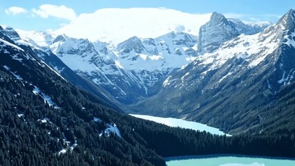 Wall Mural - Aerial shot A serene mountain range with snow-capped peaks. Bright, natural lighting to highlight the majestic scenery.