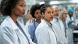 © okfoto - Serious female doctor leading diverse medical team in hospital corridor