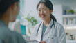 © Chatchanan - An Asian female doctor with a warm smile, presenting digital test results to a patient at a medical appointment.