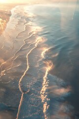 Poster - A mesmerizing aerial view captures a serene coastline bathed in golden light and caressed by gentle waves, presenting a tranquil and picturesque seascape.