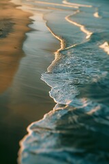 Poster - An aerial perspective reveals a sandy beach with frothy ocean waves gently rolling in, highlighting the natural beauty and rhythm of coastal elements in harmony.