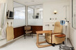 © Mint Images - Interior view of a hospital treatment cubicle with a chair and a drip treatment stand, trolley table and a television.