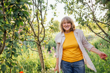 A close-up portrait of a laughing mature woman in casual clothes