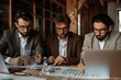 © Milos - Three serious men dressed in suits are intensely analyzing documents together in an office setting. They are deeply focused on discussing numbers and charts laid on the table.