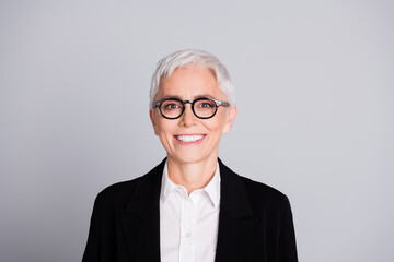 Wall Mural - Photo portrait of pretty senior female professional entrepreneur cheerful smile wear formalwear specs isolated on gray color background