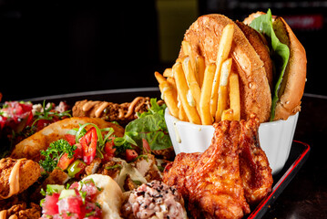 Poster - A colorful platter of fast food items including burgers, fries, and fried chicken on a dark wooden table