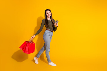 Canvas Print - Full size photo of pretty teenager girl walk shopping bags device wear trendy khaki outfit isolated on yellow color background