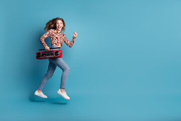 Wall Mural - Full length portrait of nice young girl jump run boombox wear top isolated on blue color background