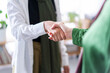 © Studio Marmellata - A close-up shot of two women shaking hands in an office setting The focus is on their hands, symbolizing agreement, partnership, and mutual respect