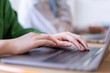 © Studio Marmellata - Close-up of a woman's hands typing on a laptop in a modern office setting The focus is on her hands and the technology used for work