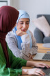 © Studio Marmellata - Two women in hijabs work intently on a laptop in a modern office environment Their focused expressions highlight their dedication and teamwork