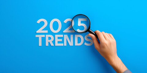 Poster - Businessman focusing on 2025 trends with magnifying glass on blue background