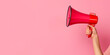 © Andres Mejia - Woman holding megaphone making announcement on pink background
