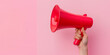 © Andres Mejia - Woman holding megaphone making announcement on pink background