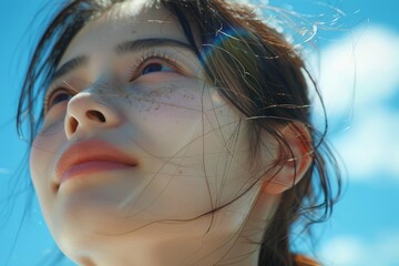 Wall Mural - Under the blue sky and white clouds, a Japanese and Korean girl looks at the close-up of the sun on the beach, with exquisite makeup and Japanese style
​