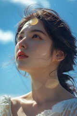 Wall Mural - Under the blue sky and white clouds, a Japanese and Korean girl looks at the close-up of the sun on the beach, with exquisite makeup and Japanese style
​