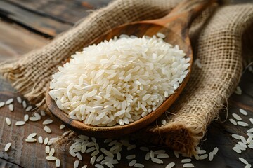 Freshly Harvested White Rice in a Wooden Spoon on Rustic Background