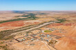 © AmazingAerialAgency - Aerial view of remote outback town Birdsville with river and desert terrain, Queensland, Australia.