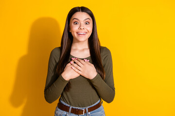 Canvas Print - Photo portrait of pretty teenager girl touch chest amazed wear trendy khaki outfit isolated on yellow color background