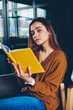 © BullRun - Portrait of two positive female teenagers spending time together at university campus, smiling millennial woman waiting telephone call on cellular sitting near friend with textbook for education