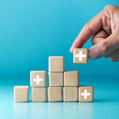Poster -  Value Add Concept- A hand places a wooden cube with a plus sign on a light blue background,_1(328)