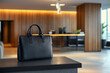 © EdvvinStudios - Black leather briefcase left on a table in a modern office