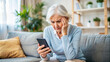 © Yekatseryna - Nervous confused elderly senior woman stressed worried with smartphone. Frustrated lady having problem with paying, buying online and payments. Internet fraud or scams
