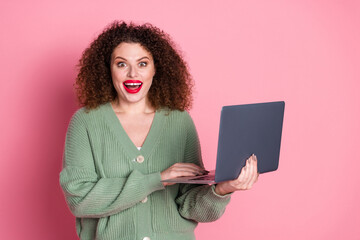 Wall Mural - Photo of cheerful excited lovely woman wear stylish khaki clothes hold modern device isolated on pink color background