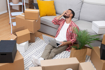 Aufkleber - Tired male thinks about moving to new modern apartment choose reliable cargo transportation service putting remaining interior items in boxes made of thick cardboard