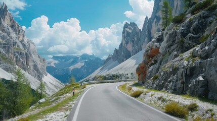 Poster - A winding road passes through a mountain valley, with a towering mountain peak in the background