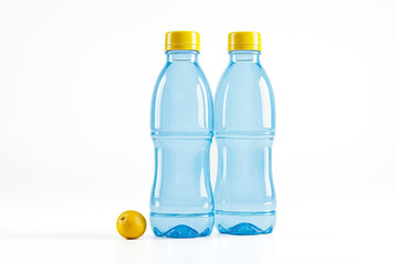 Wall Mural - Two Blue Plastic Water Bottles with Yellow Caps and a Lemon on White Background