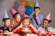 © Prostock-studio - Kids looking at birthday cake with candles, having b-day party