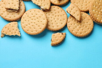 Wall Mural - Tasty sandwich cookies on light blue background, top view. Space for text