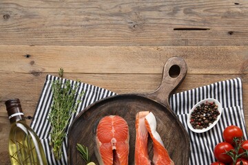 Wall Mural - Fresh salmon steaks, peppercorns and products on wooden table, flat lay. Space for text