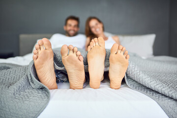 Canvas Print - Couple, feet and relax with blankets in bedroom for sleeping, tired and nap together of relationship peace on mattress. People, foot and rest for marriage commitment, dream and romance care at house