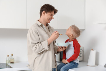 Poster - Happy father with his little son eating cornflakes on breakfast in kitchen