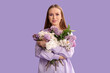 © Pixel-Shot - Beautiful young happy woman with bouquet of lilac flowers on purple background