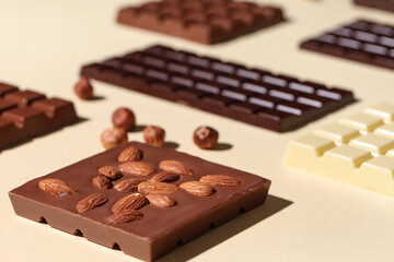 Wall Mural - Composition with tasty chocolate bars and nuts on color background, closeup