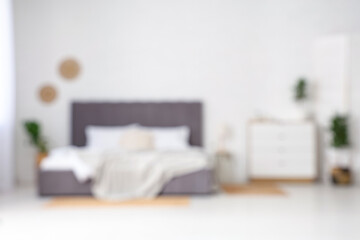 Poster - Interior of modern stylish bedroom with big bed and chest of drawers. Blurred view