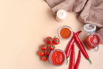 Wall Mural - Jars of tomato sauce with chili peppers on beige background