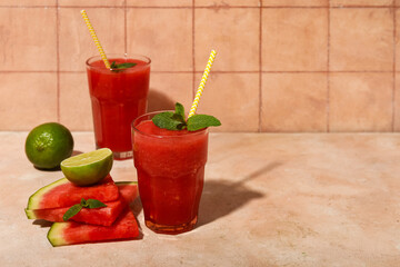 Wall Mural - Glasses of fresh watermelon juice with mint and lime on beige table