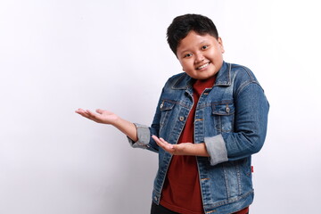 Happy little boy with hand gesture presenting to copy space isolated on white background