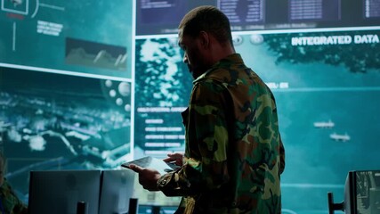 Poster - Cybersecurity specialist operates in a high tech military control center, monitoring surveillance footage and gathering intelligence for a new defense mission. Secret service activity. Camera A.