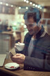 © Sanc/peopleimages.com - Business, man and smile in coffee shop with smartphone for communication and networking on break. Male person, entrepreneur and browse internet or website for stock exchange, economic news and shares