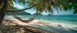 © indyntk - Gentle waves lapping on a secluded beach with a hammock swaying gently under palm trees