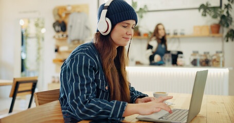 Wall Mural - Coffee shop, laptop and woman with headphones for remote work, typing email and networking. University, restaurant and person working on computer in cafe for online learning, research and education