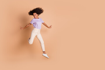 Poster - Full size photo of pretty young woman jump empty space wear t-shirt isolated on beige color background