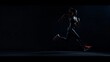 © Anna - Silhouette of athletic woman running in dark background, highlighting fitness, determination, and motion in a dynamic sports scene.