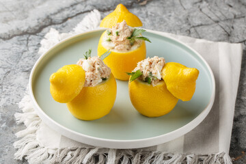 Poster - Refreshing salad inside fresh lemon with seafood, cream cheese and eggs close-up in a plate on the table. Horizontal